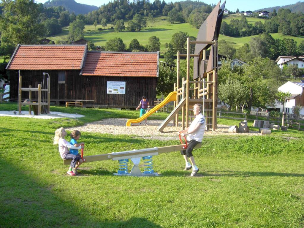 a man and two children playing at a playground at Apartment Vorreiter - UTD151 by Interhome in Uttendorf