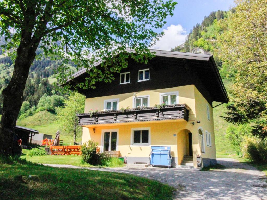 a large yellow house with a black roof at Holiday Home Bergfried - FUC150 by Interhome in Fusch an der Glocknerstraße