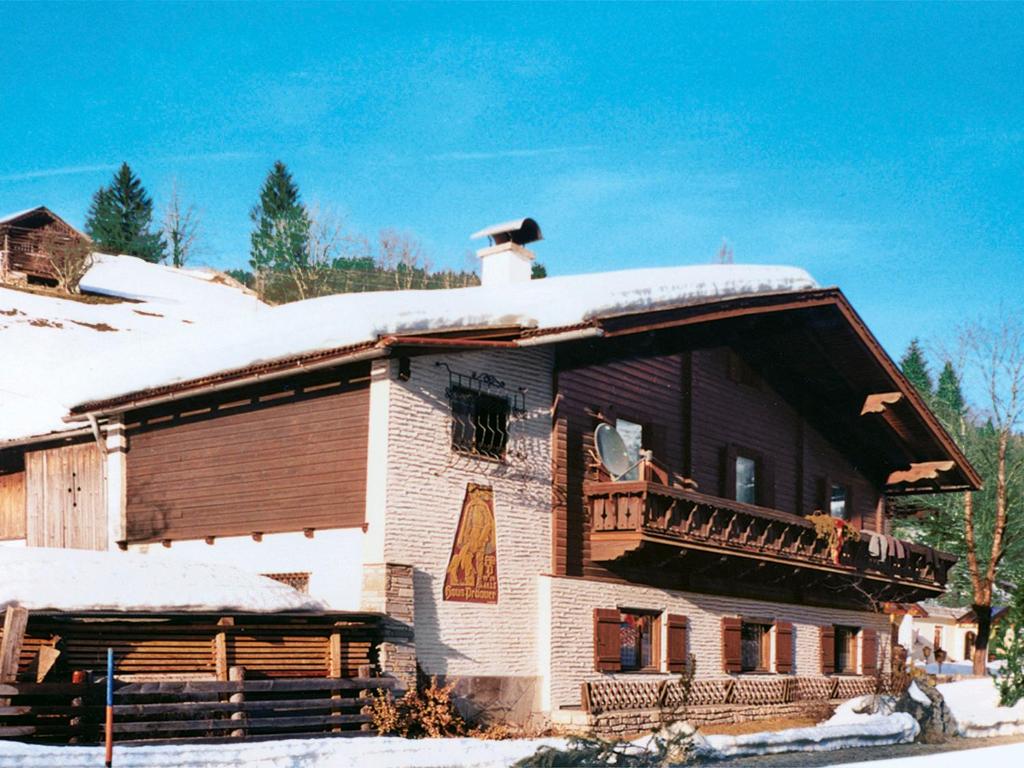 a large wooden house with a snow covered roof at Holiday Home Schwarzenegg by Interhome in Wagrain