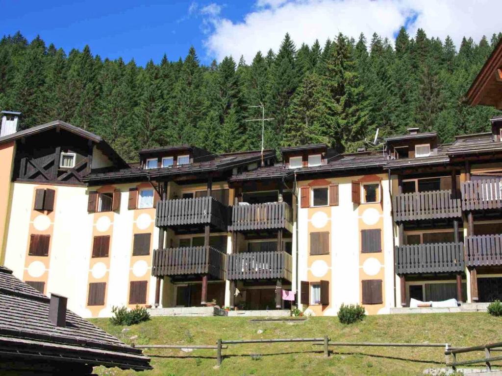 a large apartment building with balconies and trees at Apartment Fienili di Brenta-1 by Interhome in Madonna di Campiglio
