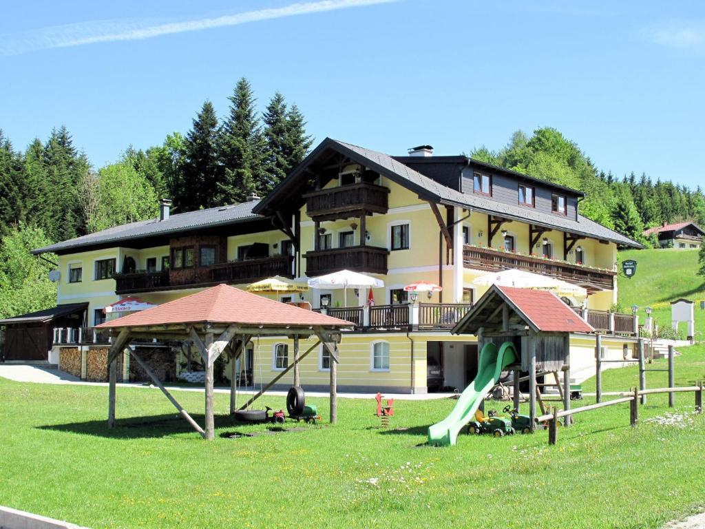 a large house with a playground in front of it at Apartment Ferienwohnung Fichte by Interhome in Oberwang