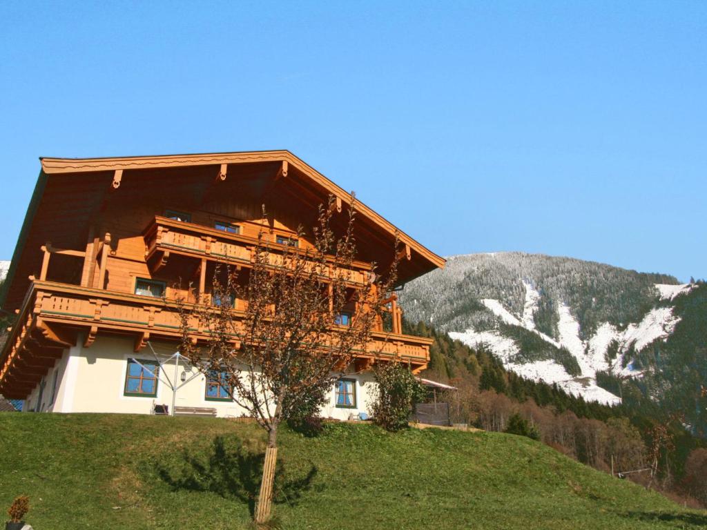 a large wooden building on a hill with a mountain at Apartment Moderegg by Interhome in Moderegg