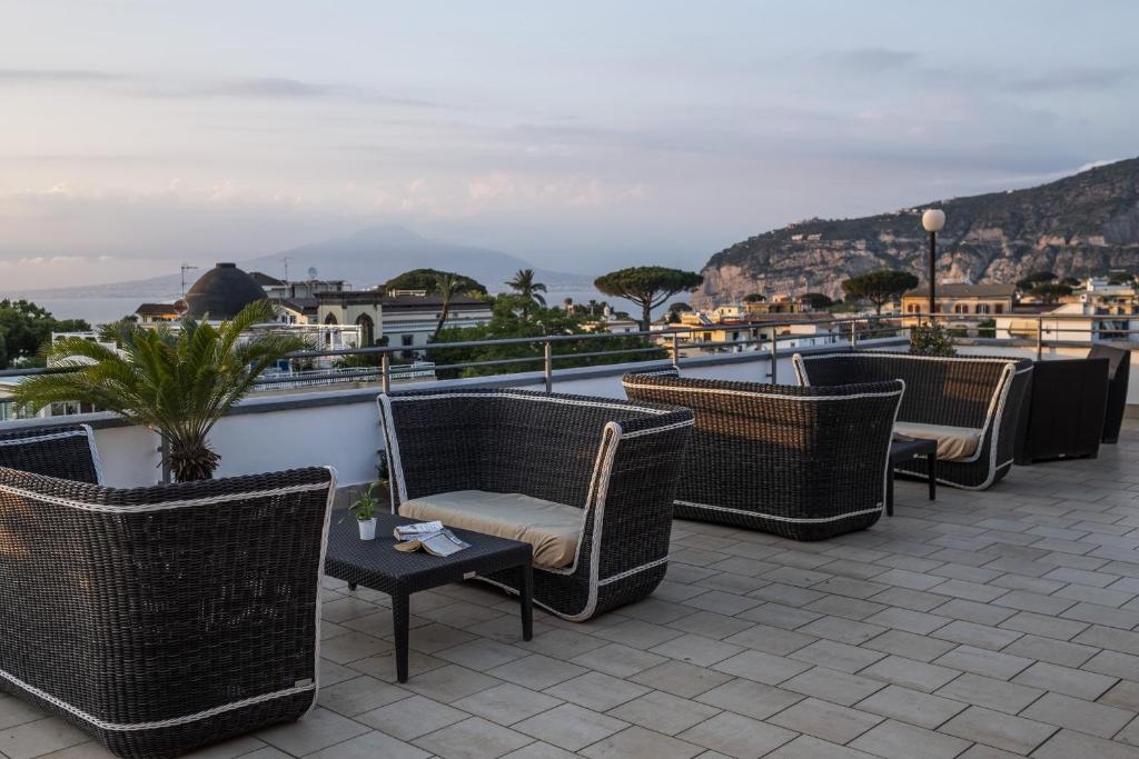 a row of wicker chairs and tables on a roof at Hotel La Pergola in Sant'Agnello