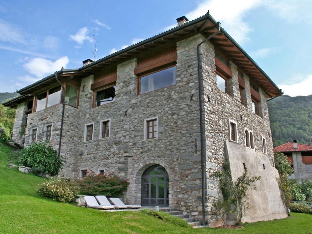 LundoにあるApartment Maso Dolcevista by Interhomeの芝生のベンチ付きの大きな石造りの家