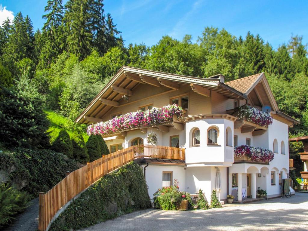 ein weißes Haus mit Blumen auf dem Balkon in der Unterkunft Apartment Kohler - FGZ121 by Interhome in Fügen