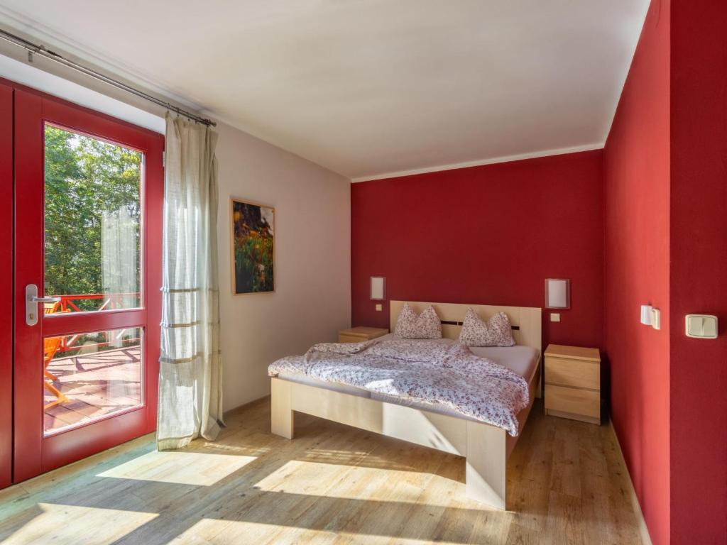 sypialnia z łóżkiem i czerwoną ścianą w obiekcie Studio Na mechu-1 by Interhome w mieście Mezná