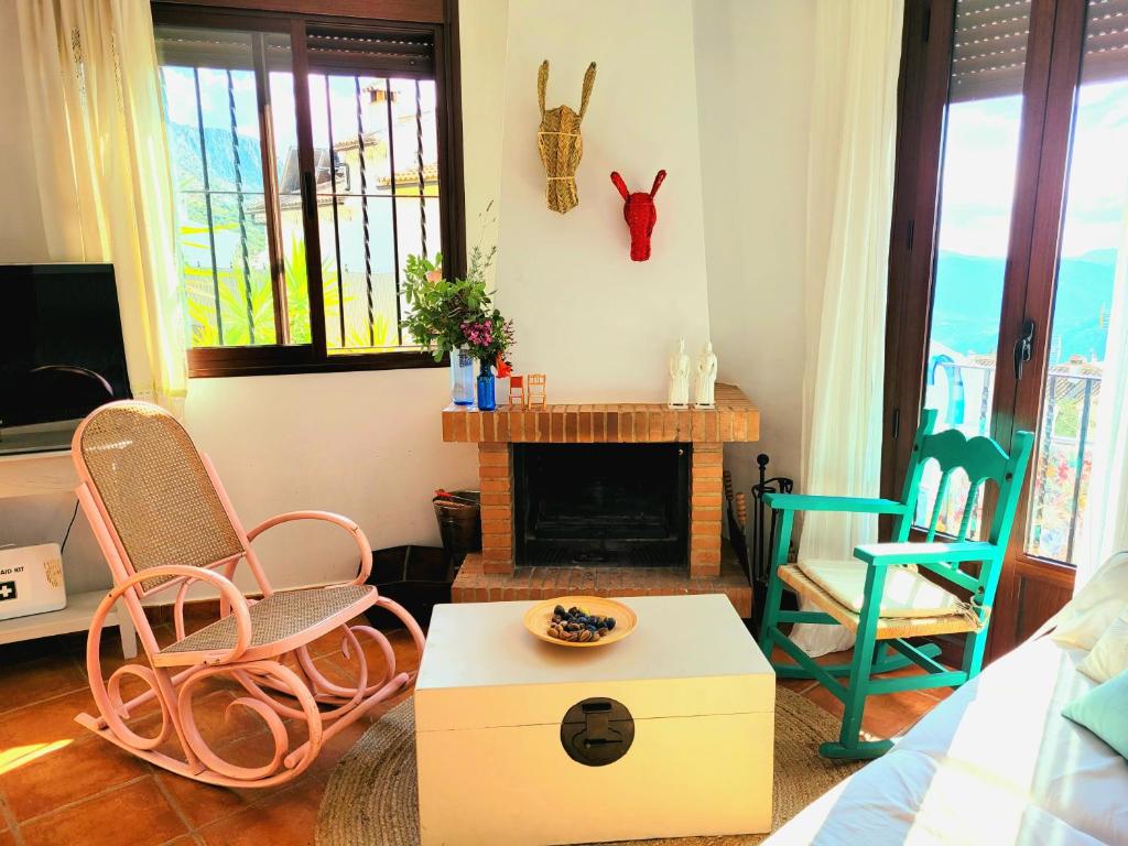 uma sala de estar com duas cadeiras e uma lareira em Luminoso con vistas y chimenea apto mascotas em Benaocaz