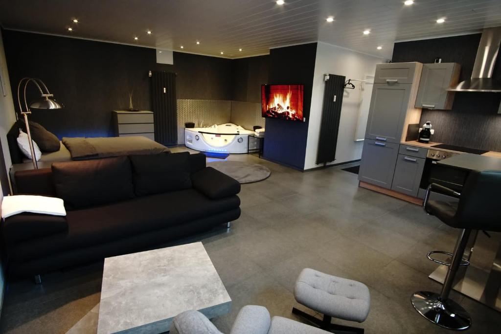 ein Wohnzimmer mit einem Sofa und eine Küche mit einem Kamin in der Unterkunft Luxus-Appartement in Übach-Palenberg
