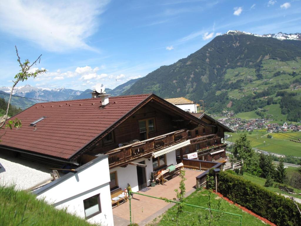 a house with a roof with mountains in the background at Apartment Unterkreuter - KAB215 by Interhome in Kaltenbach