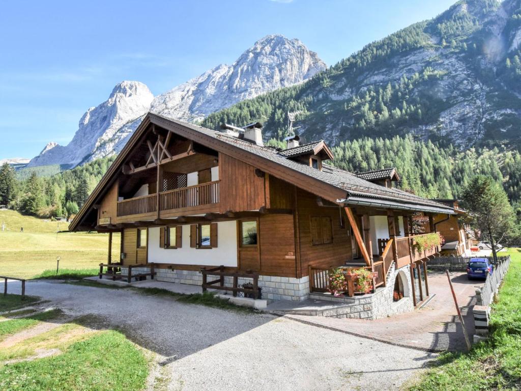 a log house with mountains in the background at Apartment Cesa Galaldriel-2 by Interhome in Penia