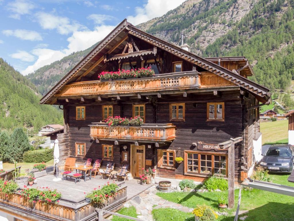 a large wooden house with flowers on the porch at Apartment Beim Holzschnitzer-1 by Interhome in Sölden