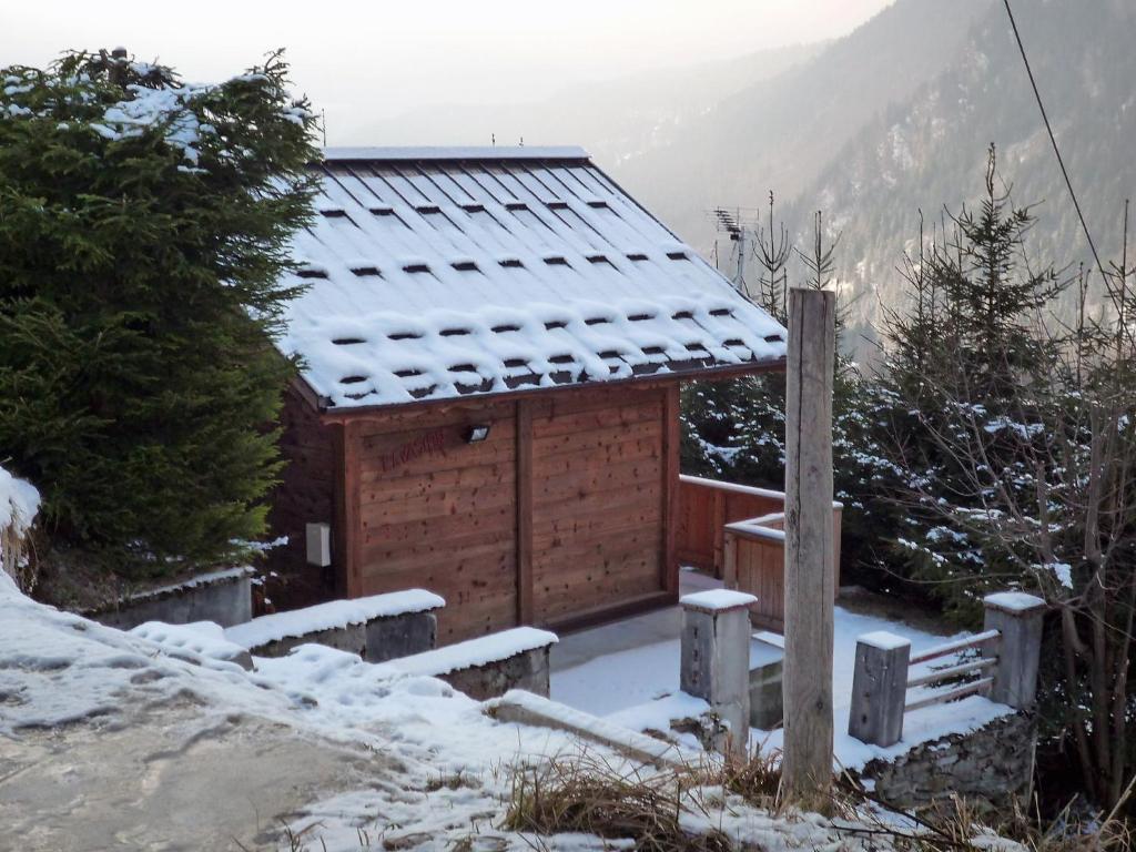 a wooden cabin with snow on the roof at Chalet Evasion by Interhome in Les Bossons