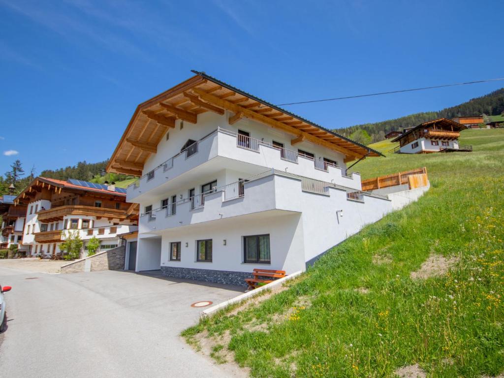 un edificio en una colina al lado de una carretera en Apartment Anton - MHO561 by Interhome, en Ramsau im Zillertal