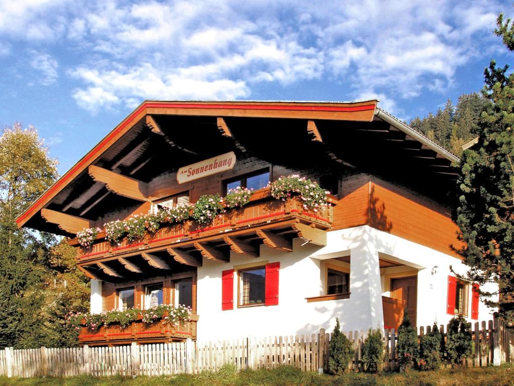 a house with flowers on the front of it at Holiday Home Haus am Sonnenhang by Interhome in Spielbichl