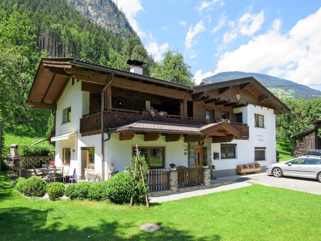 a house in the mountains with a car parked in front at Apartment Anger - MHO163 by Interhome in Mayrhofen