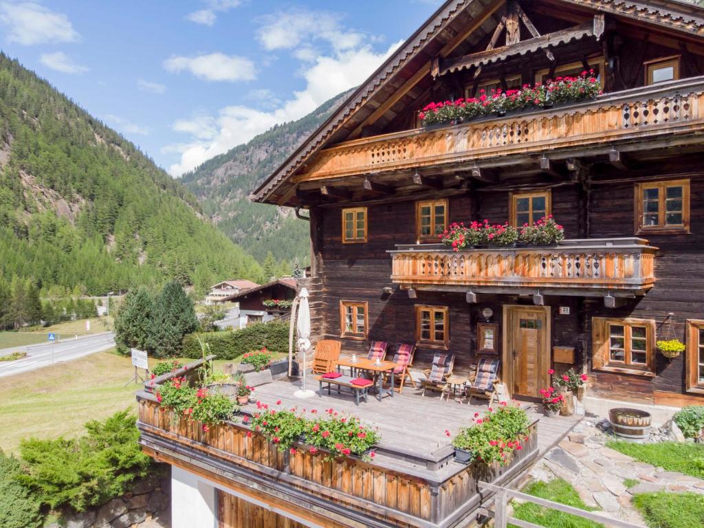 a large wooden house with flowers on the balcony at Apartment Beim Holzschnitzer-4 by Interhome in Sölden