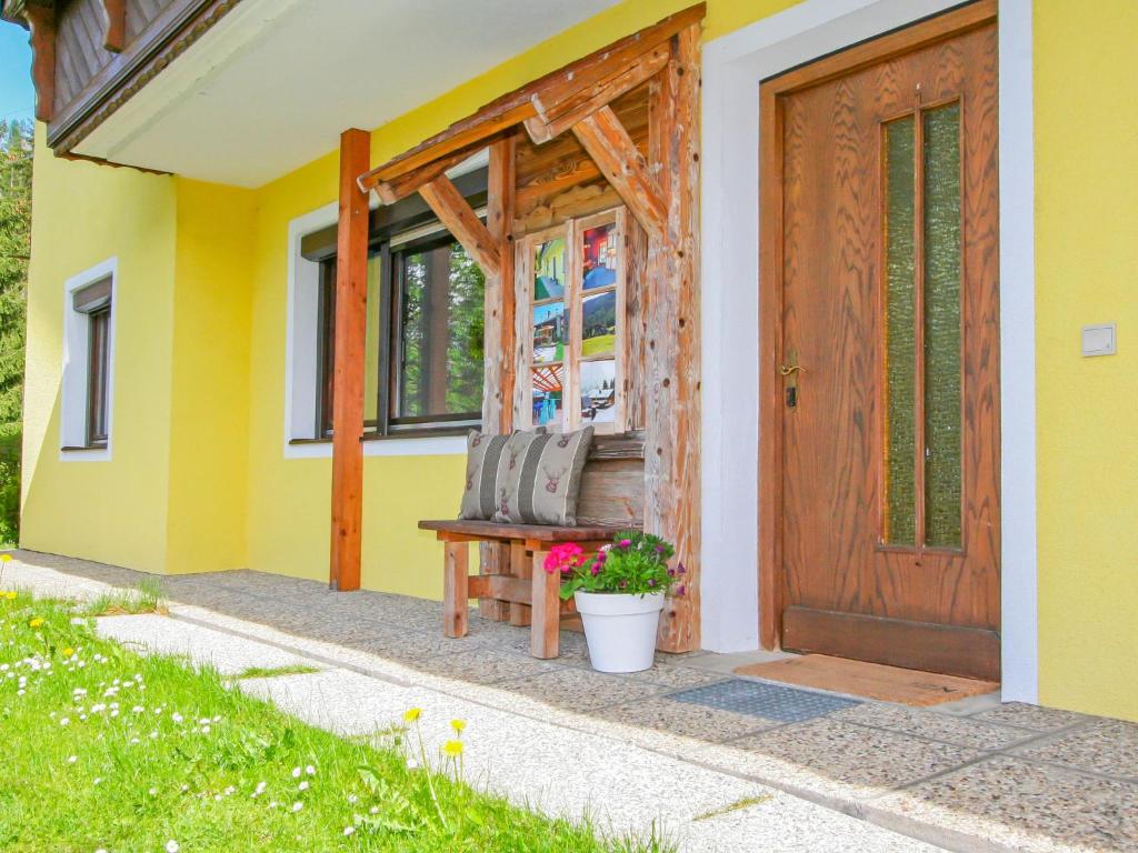a yellow house with a bench in front of a door at Holiday Home Haselwanter by Interhome in Sellrain