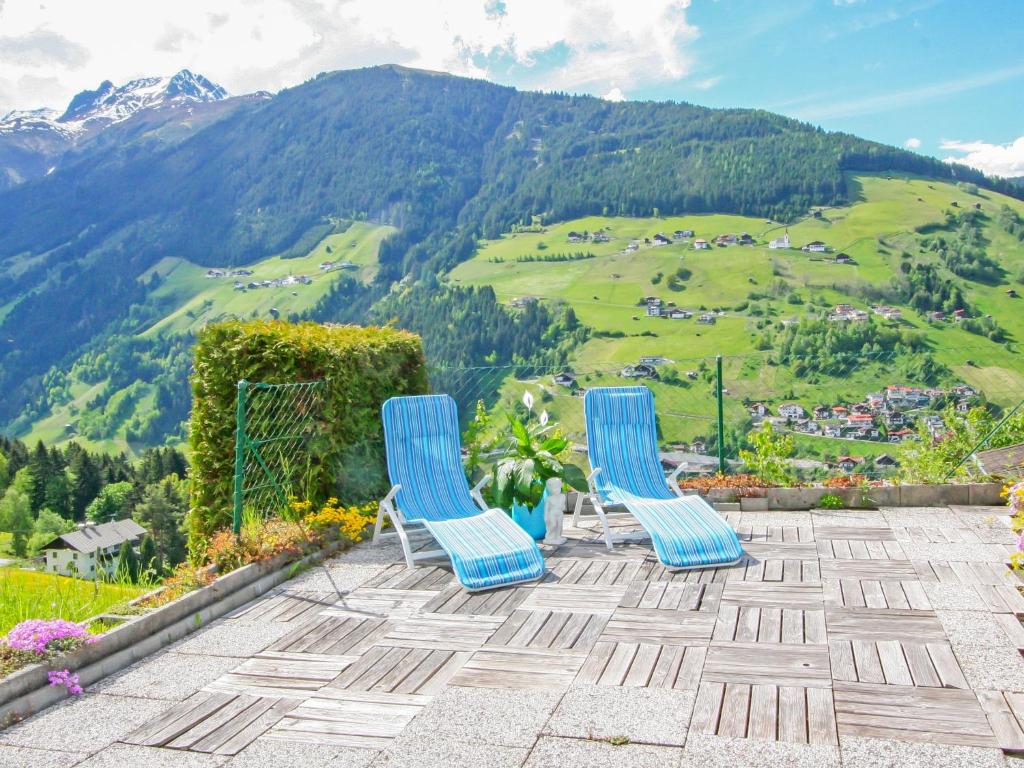two blue chairs on a patio with a view of a mountain at Holiday Home Haselwanter by Interhome in Sellrain