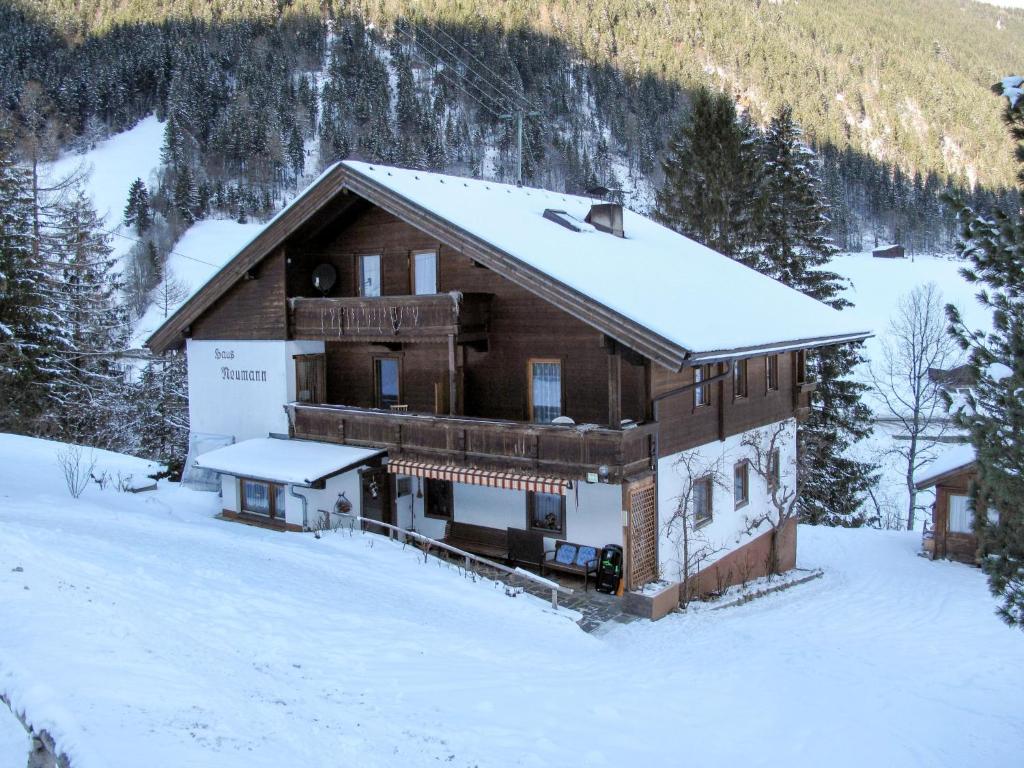 een groot houten huis in de sneeuw met sneeuw bij Apartment Neumann - FBZ202 by Interhome in Finkenberg