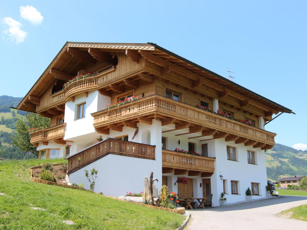 ein Haus mit Holzbalkonen auf einem Hügel in der Unterkunft Apartment Gasteighof-4 by Interhome in Kapfing