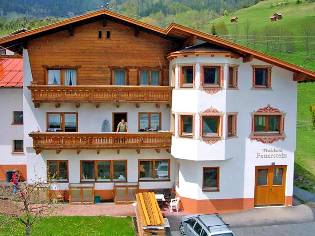 una casa grande con una mujer parada en el balcón en Apartment Werner by Interhome, en Pettneu am Arlberg