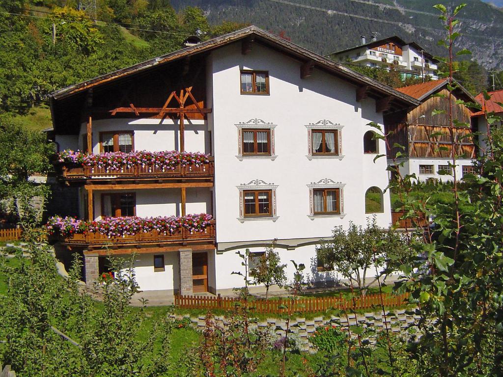 ein weißes Haus mit Blumen auf den Balkonen in der Unterkunft Apartment Krismer by Interhome in Pians