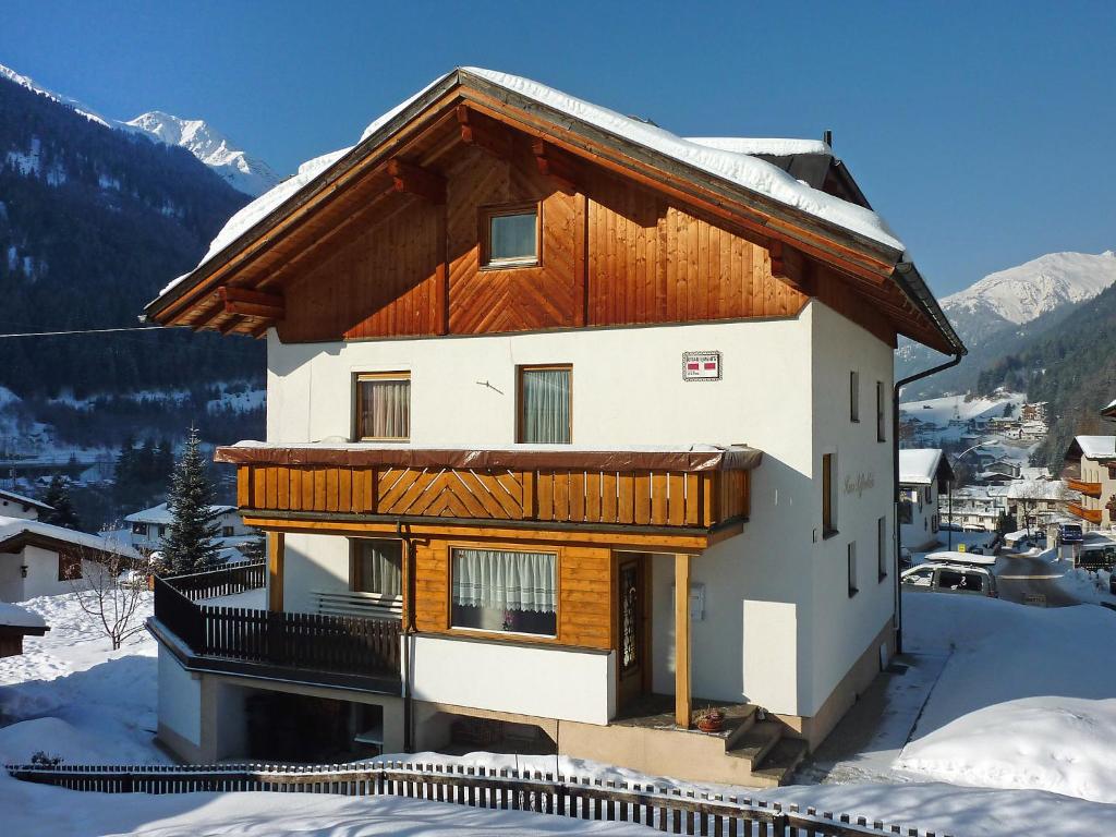 una casa en la nieve con montañas en el fondo en Apartment Rifflerblick by Interhome en Pettneu am Arlberg