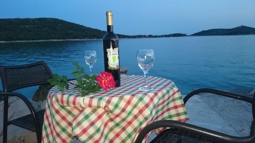uma mesa com uma garrafa de vinho e dois copos em Guest House Loranum em Sevid