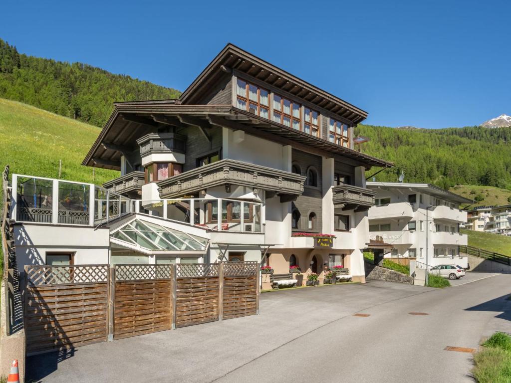 ein Haus in den Bergen mit einem Zaun in der Unterkunft Apartment Nadine - SOE405 by Interhome in Sölden