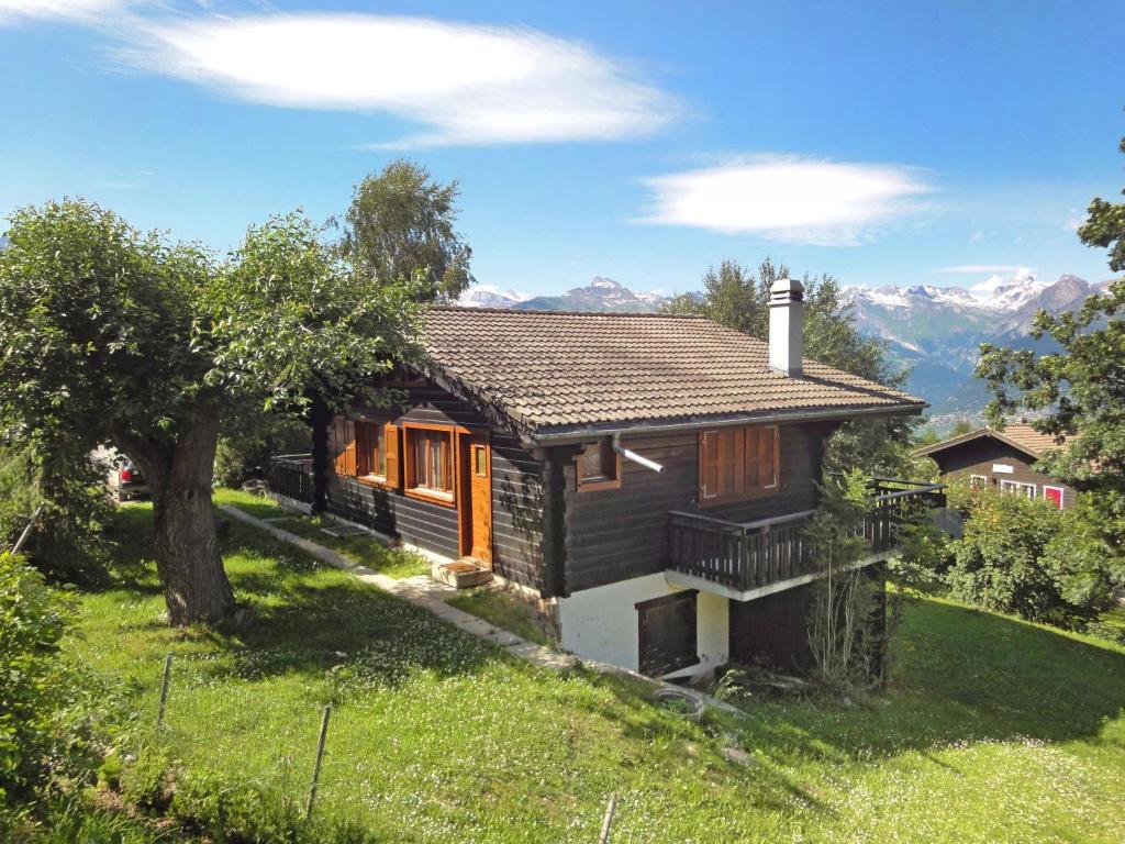 a small house on a hill with mountains in the background at Chalet Sven Heul by Interhome in Nendaz
