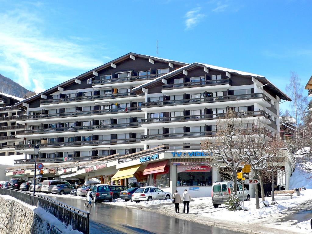 ein großes Gebäude mit davor geparkt in der Unterkunft Apartment Valaisia 34A by Interhome in Nendaz