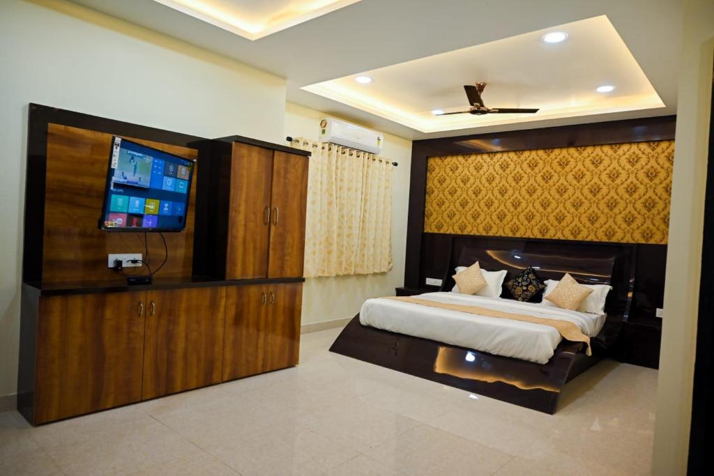 um quarto com uma cama grande e uma televisão de ecrã plano em Hotel Golden Bliss em Bhopal