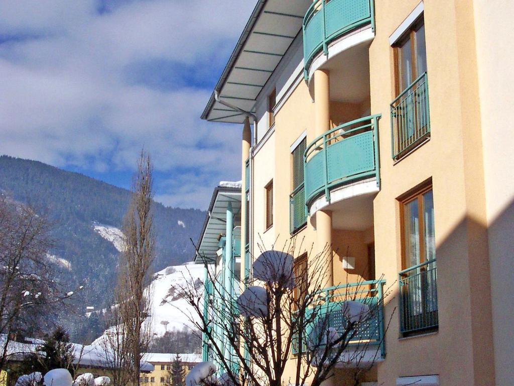 een gebouw met een met sneeuw bedekte berg op de achtergrond bij Apartment Haus Kitzsteinhorn by Interhome in Zell am See