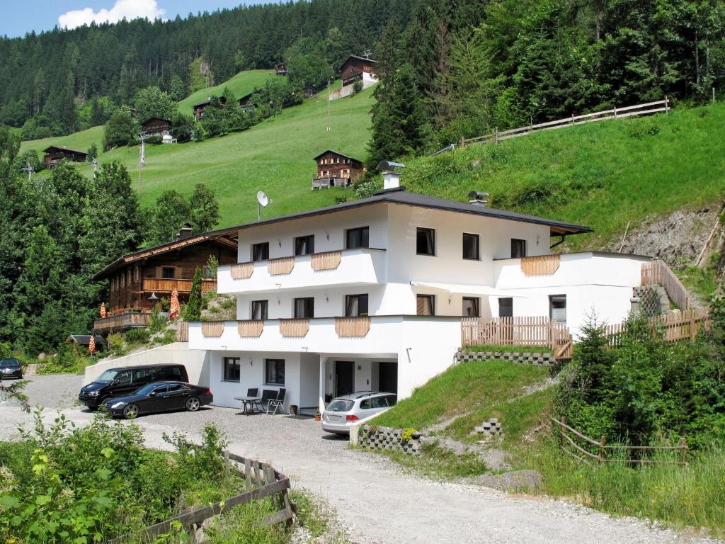 een wit huis met auto's geparkeerd op een parkeerplaats bij Apartment Edelweiss - MHO527 by Interhome in Ramsau im Zillertal