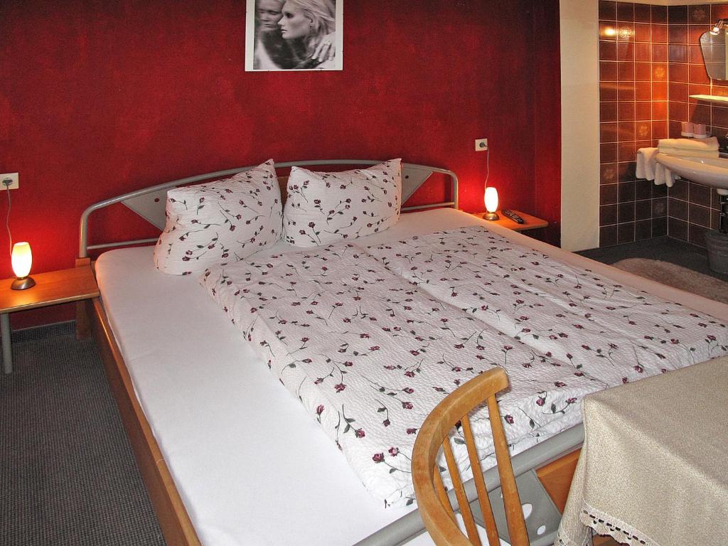 Posto letto in camera con parete rossa. di Apartment Babsi by Interhome a Ginzling