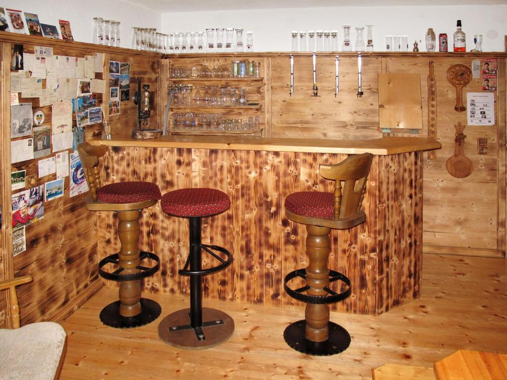un bar con sgabelli in una stanza con pareti in legno di Apartment Babsi by Interhome a Ginzling