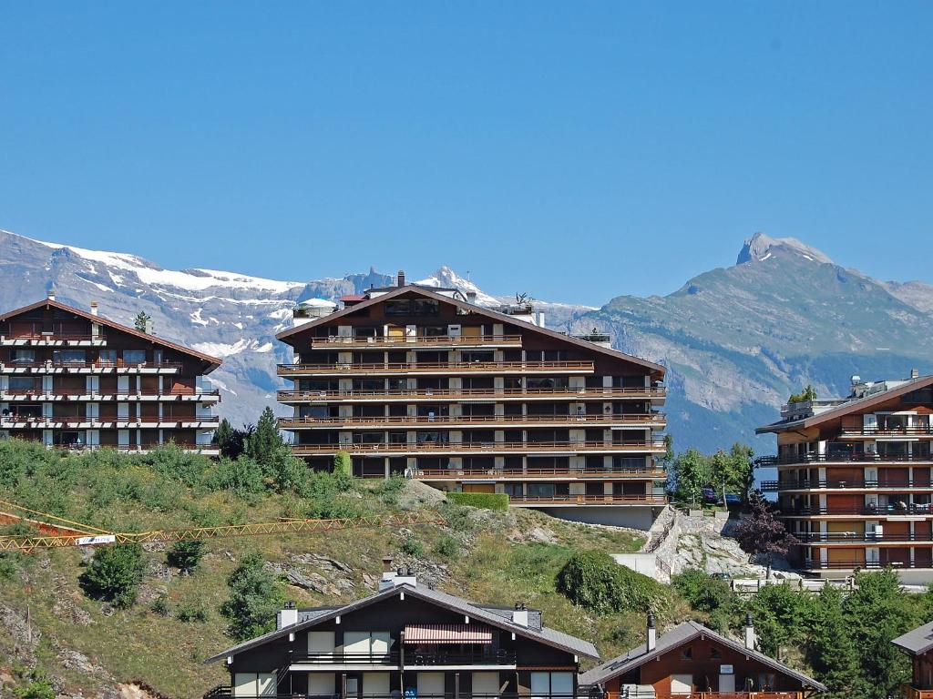 a group of buildings on a hill with mountains at Apartment Nid d'aigle E1 by Interhome in Nendaz