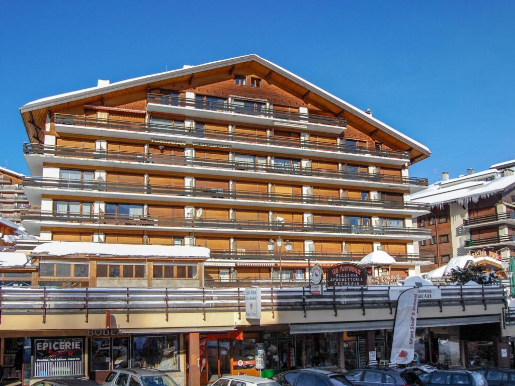 ein großes Gebäude mit davor geparkt in der Unterkunft Apartment Bouleaux I4 by Interhome in Nendaz