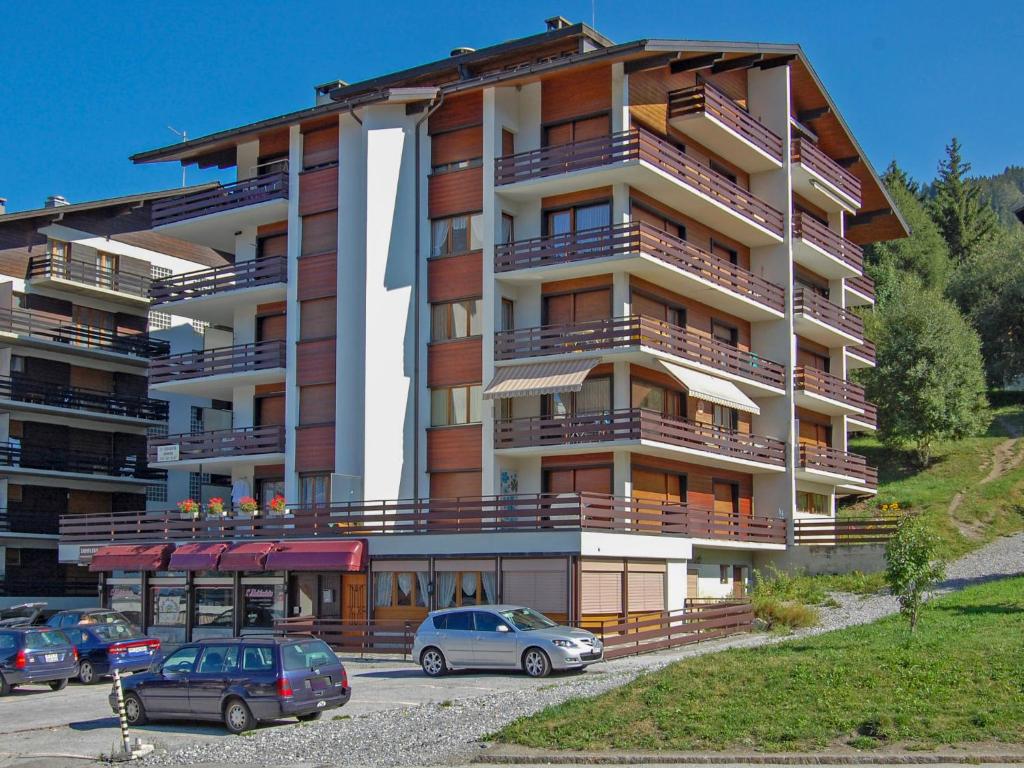 ein Gebäude mit Autos auf einem Parkplatz in der Unterkunft Apartment Zanfleuron A1 by Interhome in Nendaz