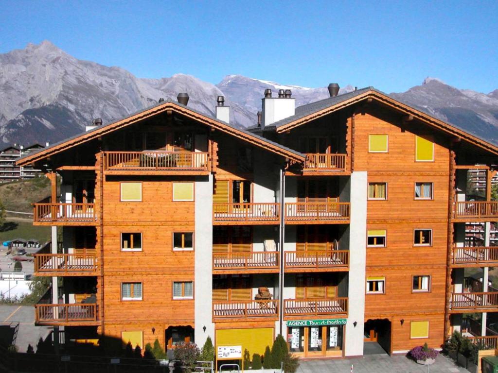 duży budynek apartamentowy z górami w tle w obiekcie Apartment Les Chouettes 1 by Interhome w mieście Nendaz