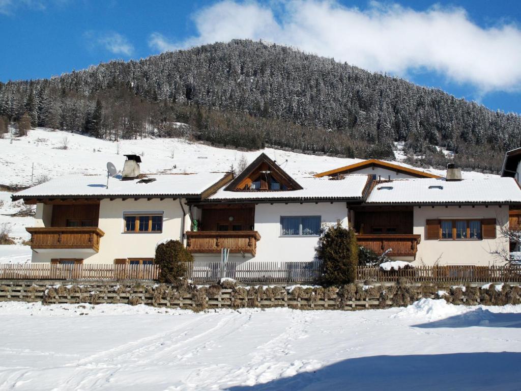 a house in the snow with a mountain in the background at Apartment Steinwender by Interhome in Nauders