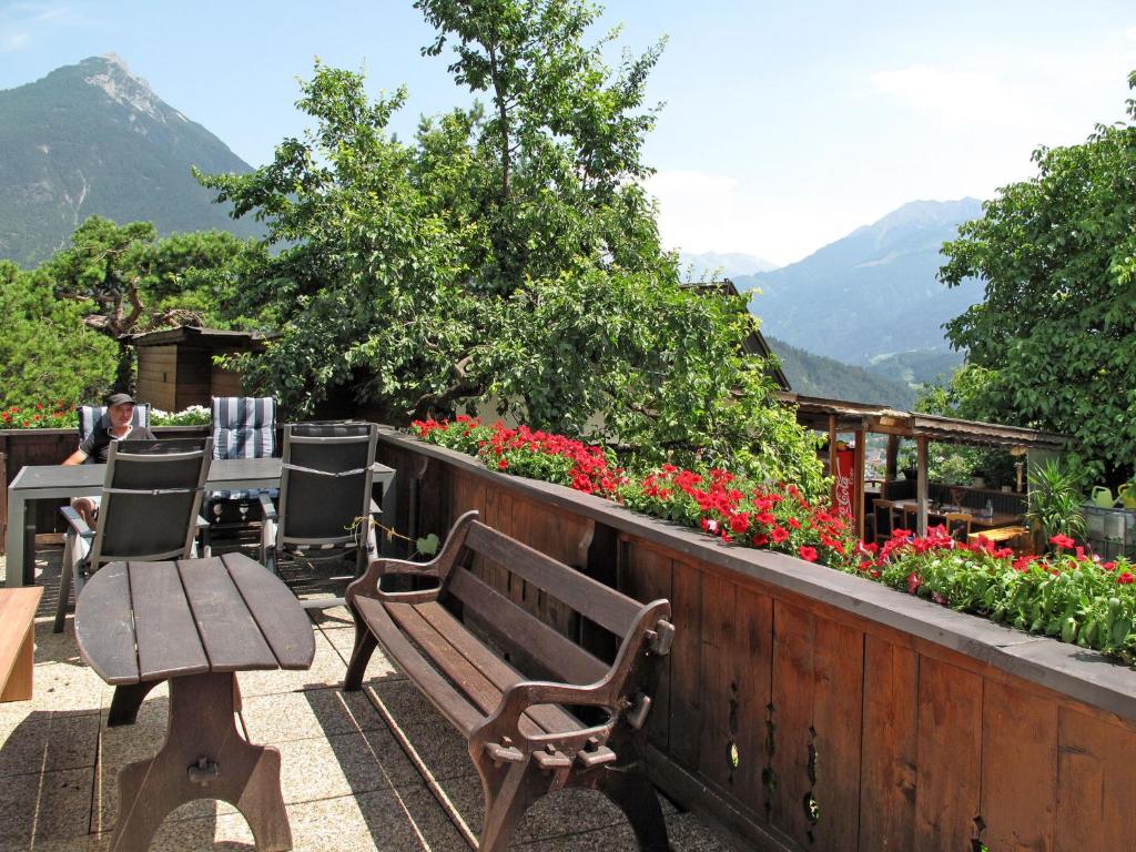 un balcone fiorito con panchina, tavoli e sedie di Apartment Anich by Interhome a Imst