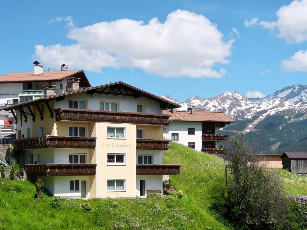 un bâtiment sur une colline avec des montagnes en arrière-plan dans l'établissement Apartment Ferienglück - KPL393 by Interhome, à Kappl