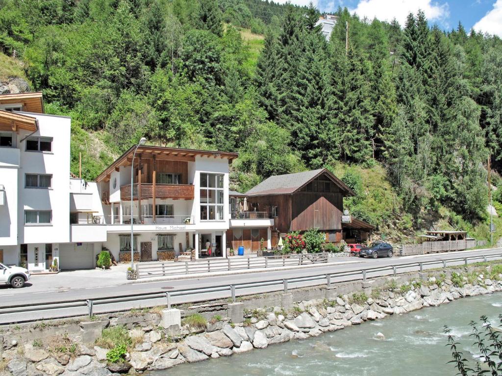 a building on the side of a road next to a river at Apartment Michael by Interhome in Kappl
