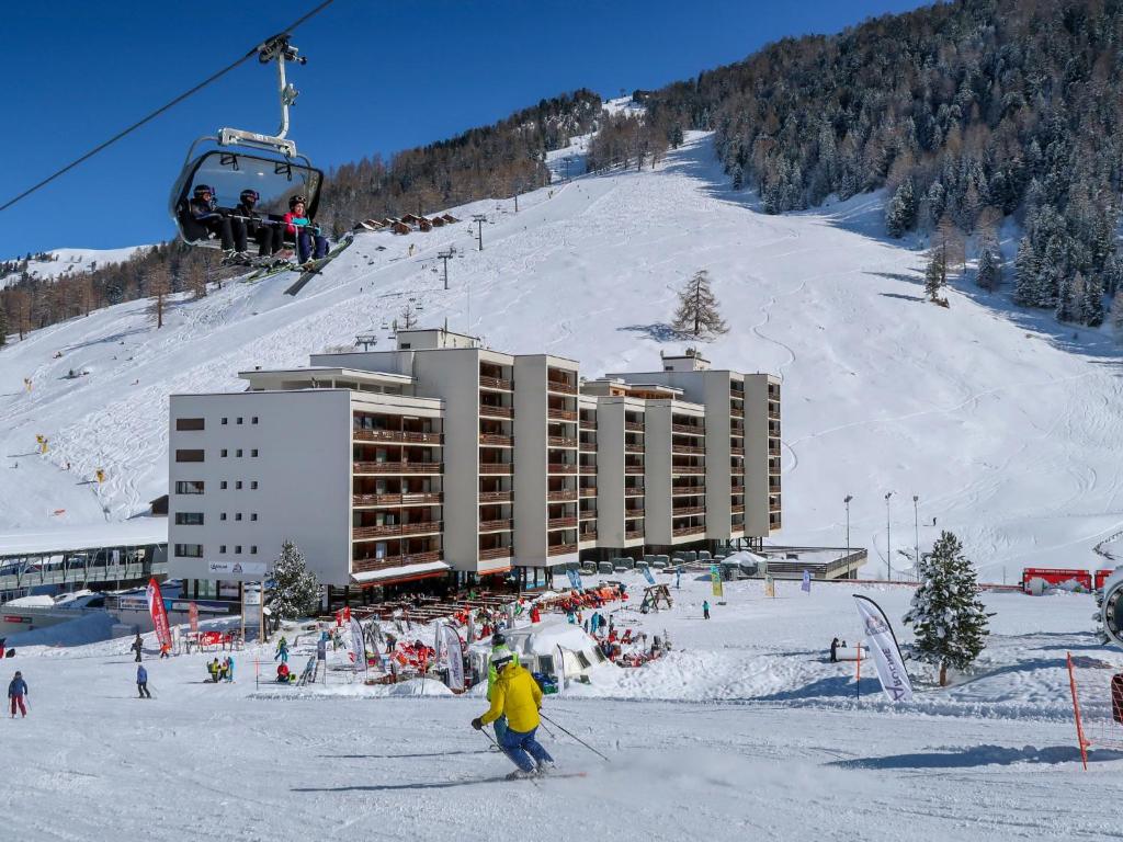 a group of people skiing on a ski slope with a ski lift at Apartment Rosablanche D32 by Interhome in Siviez