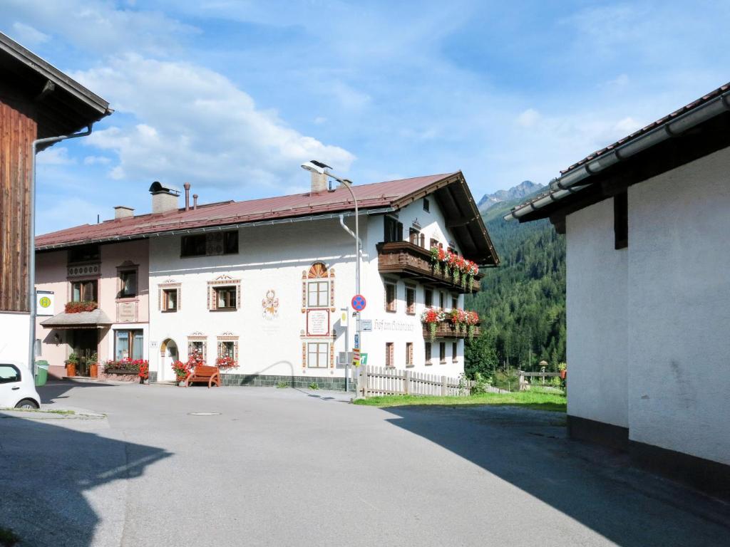a large white building with a balcony on a street at Apartment Hof am Schönbach-1 by Interhome in Sankt Jakob