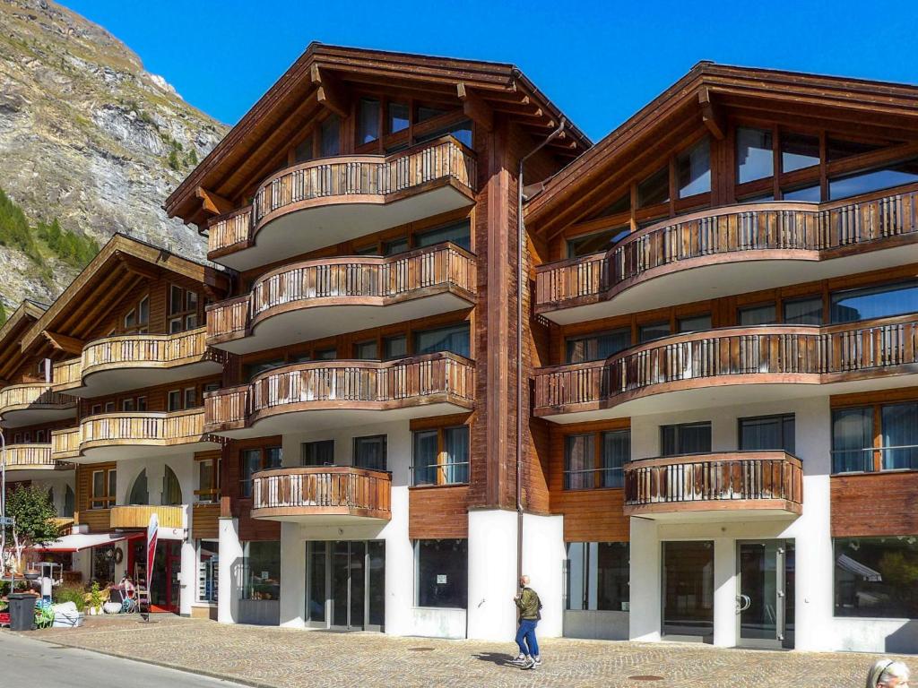 Un uomo in piedi di fronte a un edificio di Apartment Zur Matte B-11 by Interhome a Zermatt