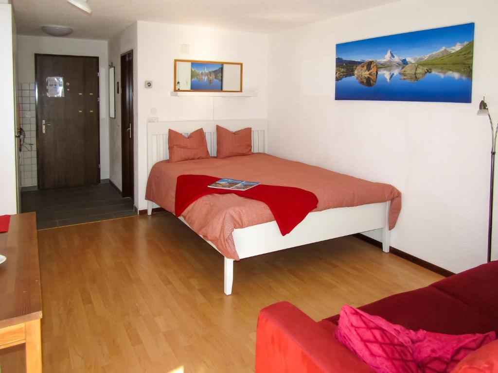 um quarto com uma cama e um sofá em Apartment Sungold-2 by Interhome em Zermatt
