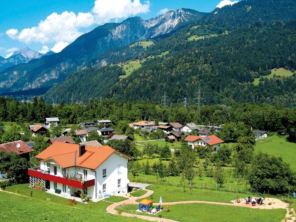 a house in a field with mountains in the background at Apartment Schmidt - VNN140 by Interhome in Vandans