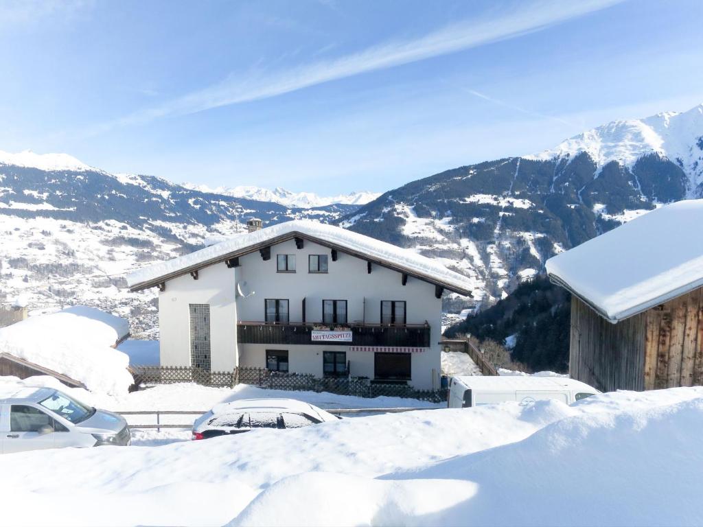 uma casa na neve com montanhas ao fundo em Holiday Home Mittagspitze - TCH200 by Interhome em Schruns